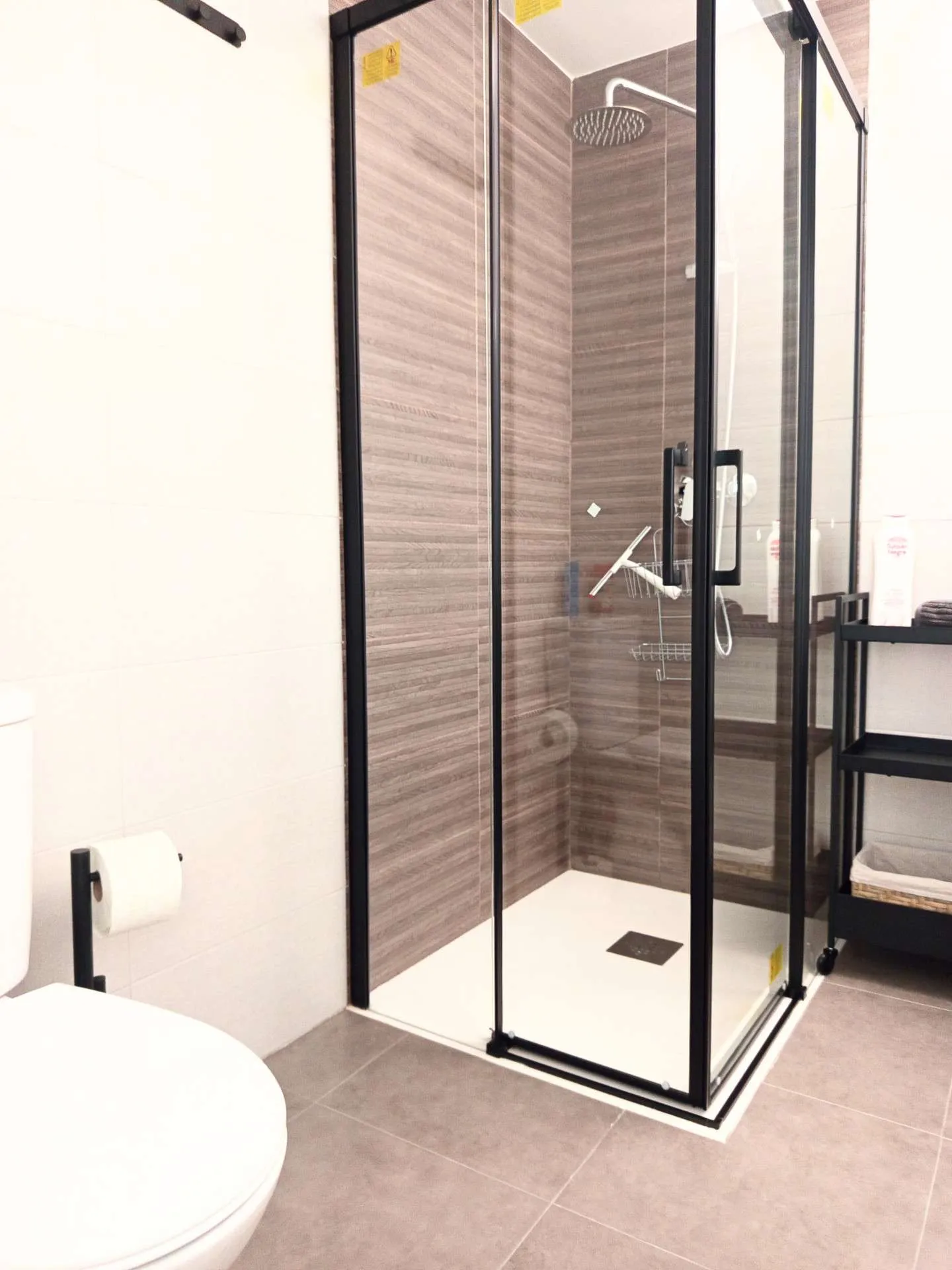 Łazienka z toaletą i kabiną prysznicową w ciemnych odcieniach