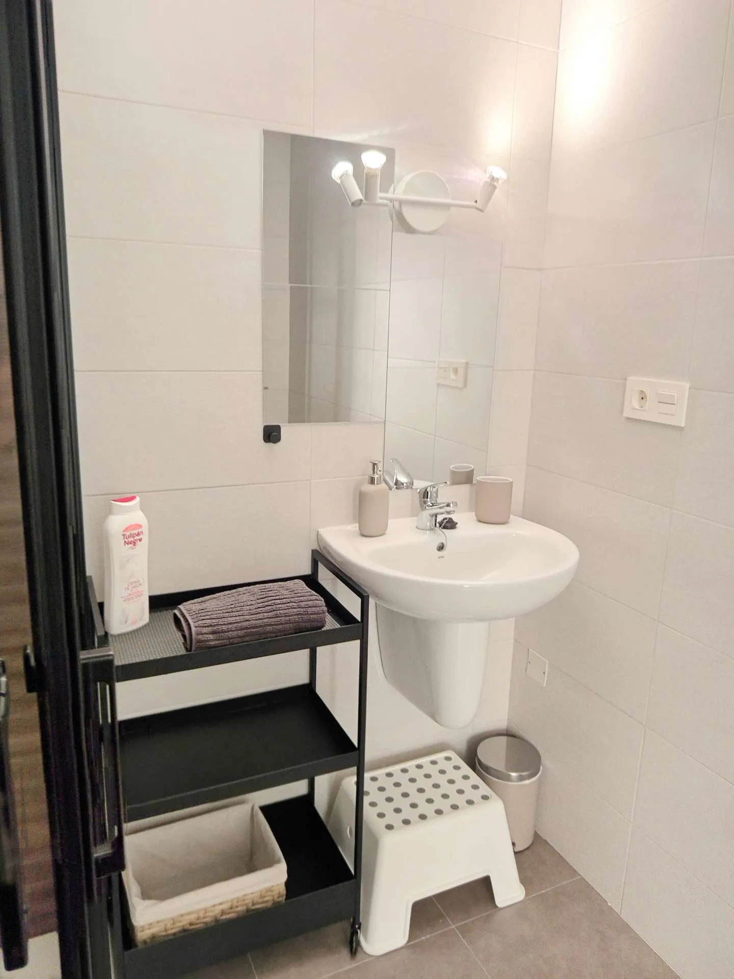 Łazienka — umywalka z lustrem, półka z kosmetykami i ręcznikami