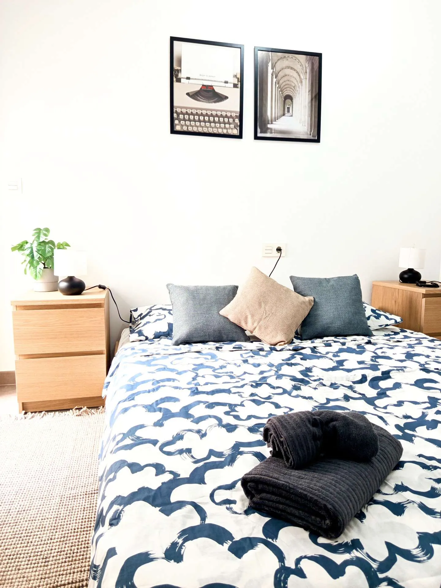 Druga sypialnia z niebieską pościelą i drewnianymi szafkami nocnymi