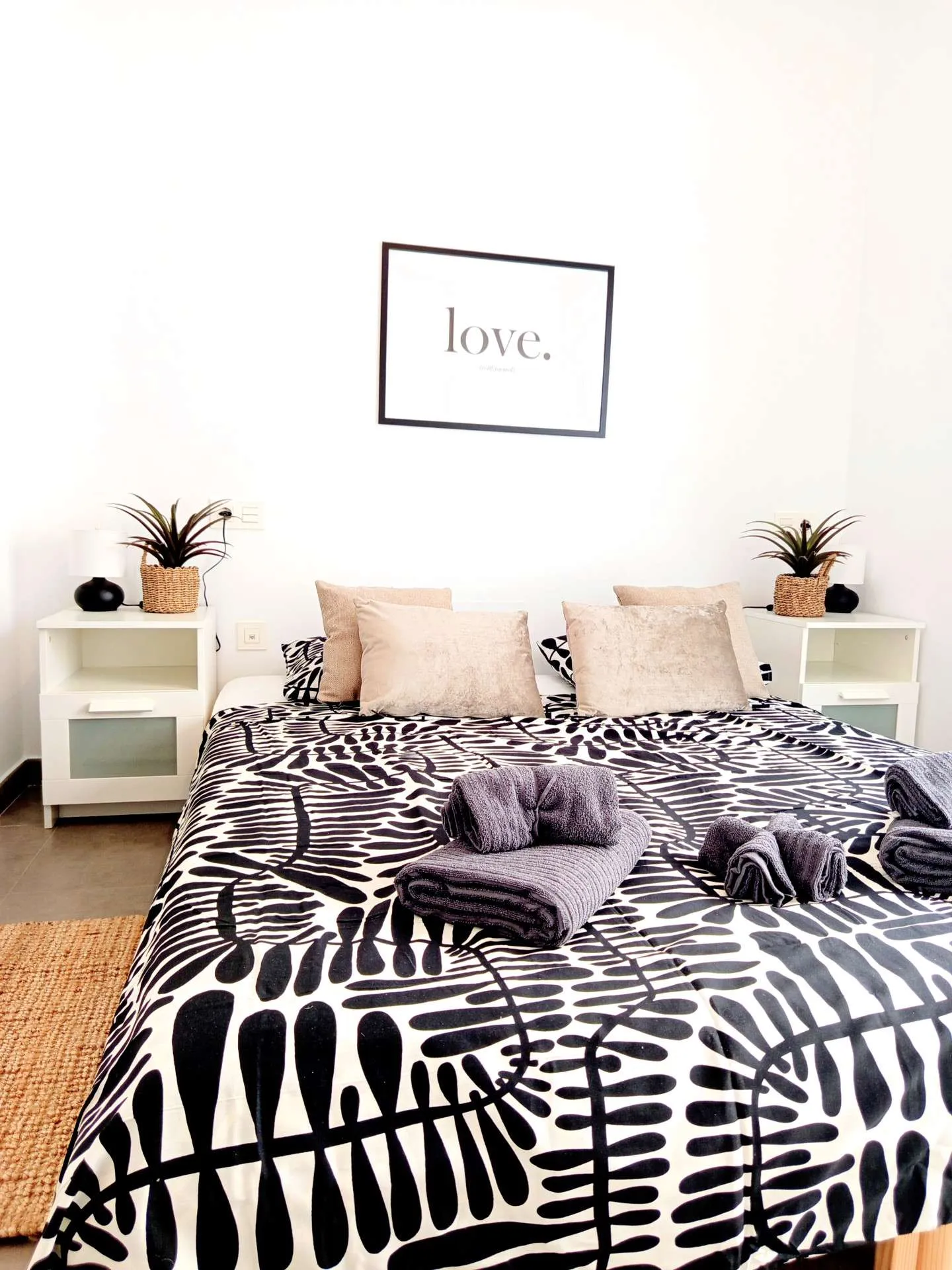 Sypialnia główna z elegancką czarno-białą pościelą i plakatem love
