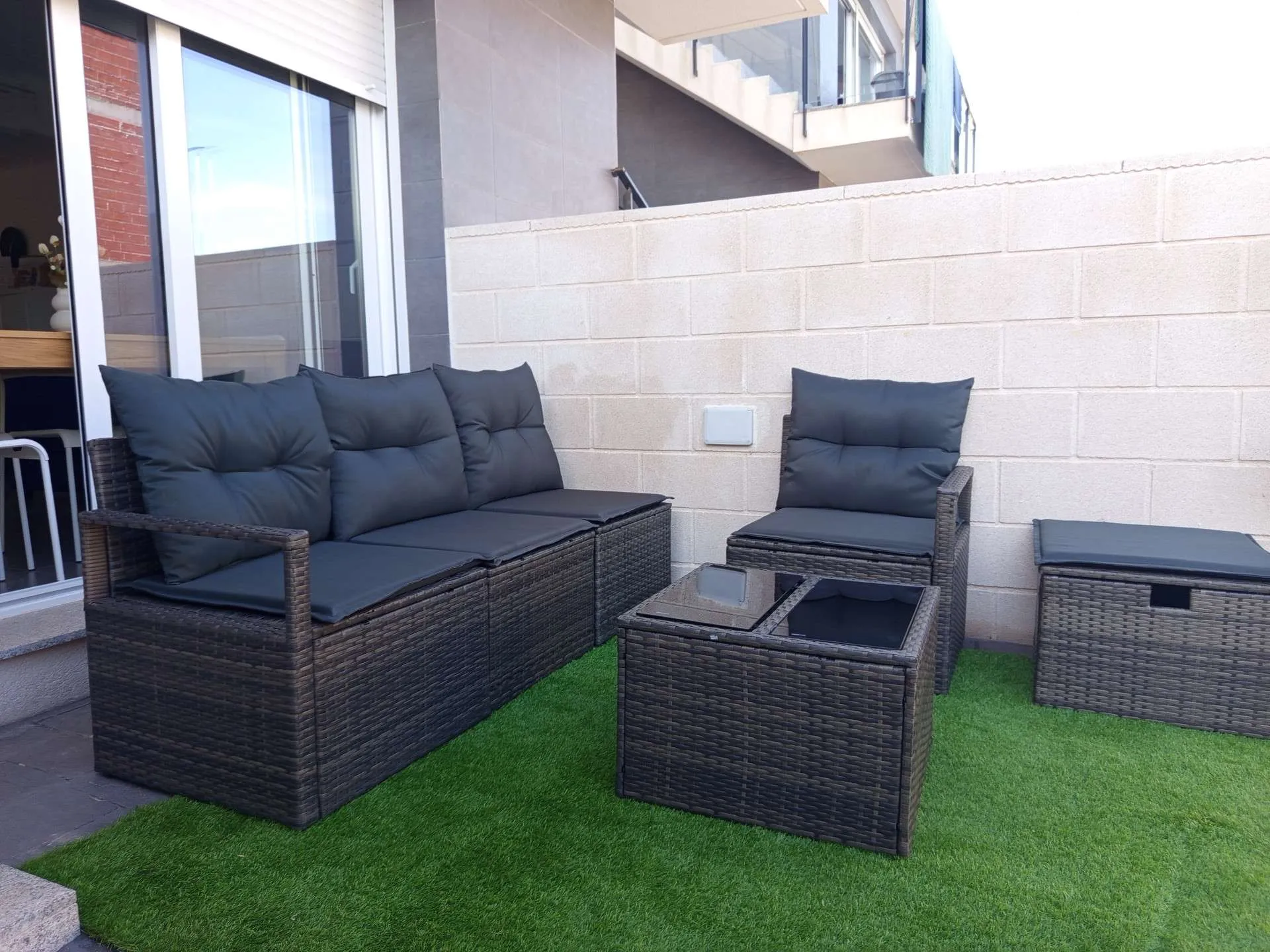 Strefa wypoczynkowa na tarasie z kanapą i fotelem rattanowym