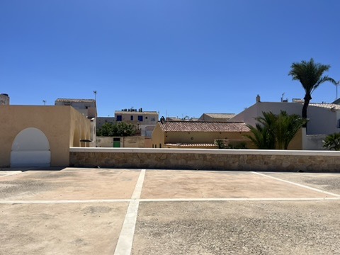 Wąskie uliczki miasta Tabarca wyłożone kamieniem z białymi domkami i niebieskimi detalami