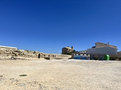 Białe domki z niebieskimi okiennicami w historycznym centrum Tabarcy