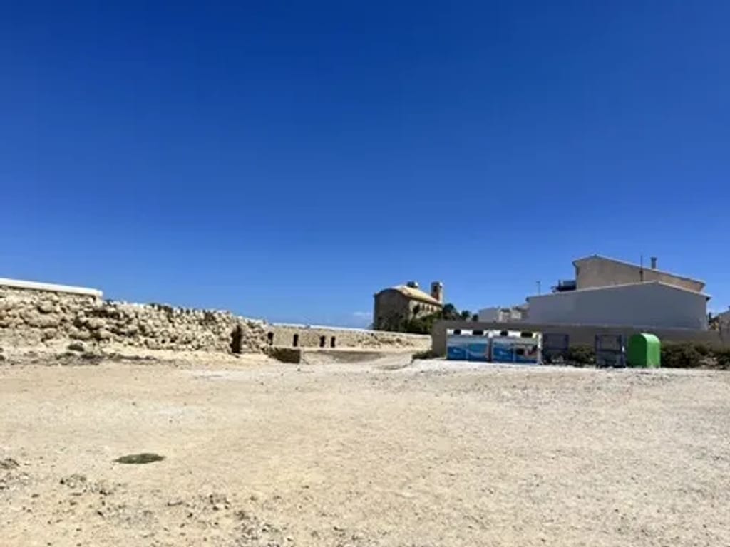 Białe domki z niebieskimi okiennicami w historycznym centrum Tabarcy